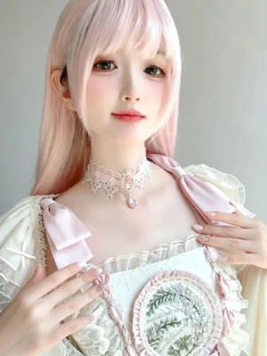Sweet lolita pink rhinestone lace choker with pink teardrop pendant on long-haired model in soft pink dress