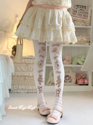 Pink sweet lolita velvet printed tights featuring bunny bow motifs and striped ankle cuffs worn with cream ruffled lolita skirt and pink mary jane shoes in vintage doll bedroom setting