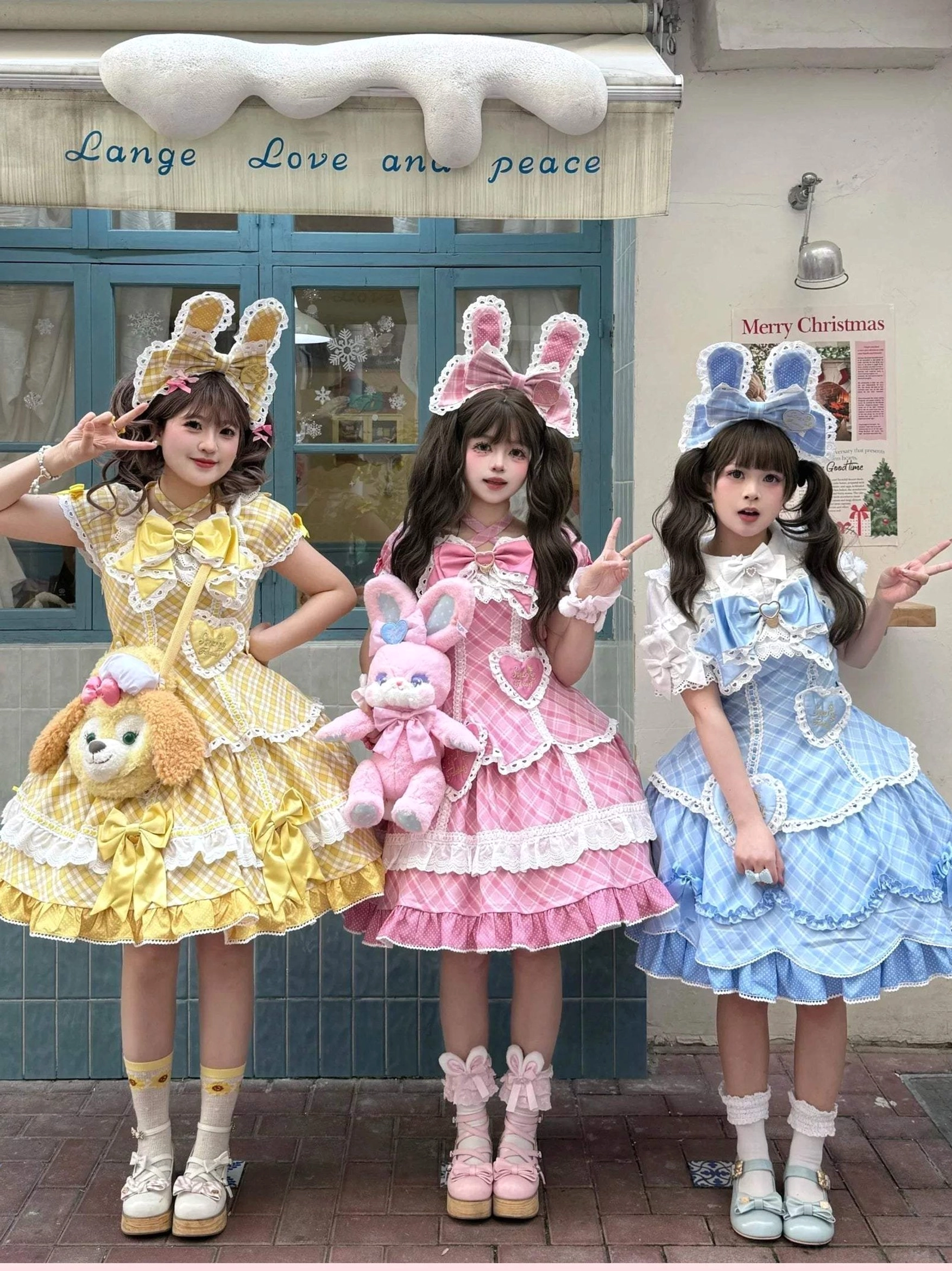 Three-color sweet plaid lolita OP one-piece dresses triple model front full-body view in yellow pink and blue gingham with matching bunny ear hair accessories and themed crossbody bags, retro street storefront scene with vintage signage