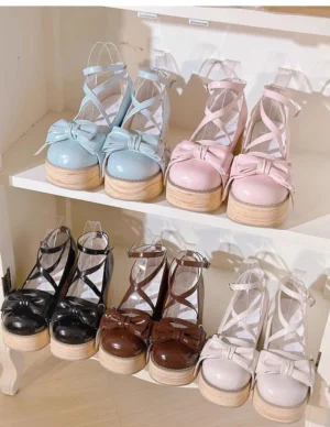 Overhead display of sweet lolita platform heels in five color variants on white wooden shelf showing black dark brown ivory pink and sky blue options with glossy patent leather and wood grain platform soles