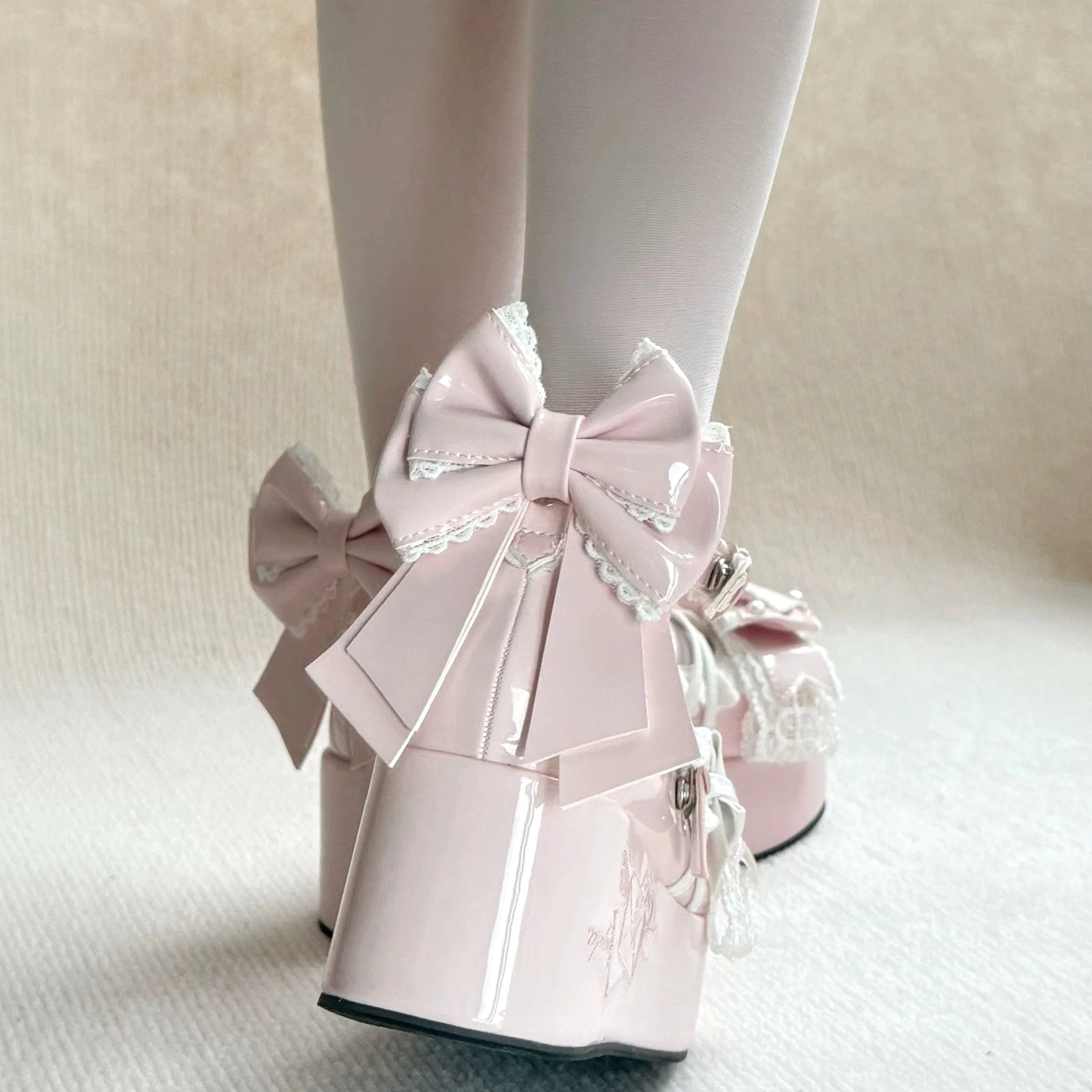 Light pink Sweet Lolita platform shoes rear on-foot display featuring oversized satin bowknot at heel, glossy patent leather platform, delicate lace vamp decorations, white sheer stockings
