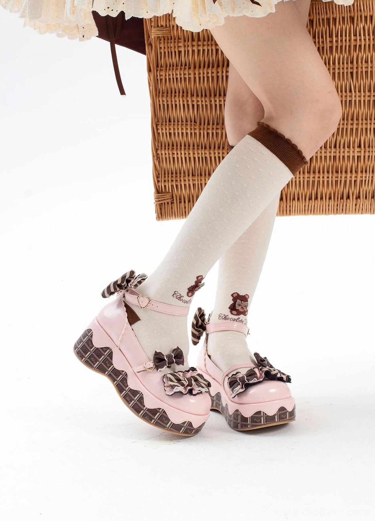 Pink sweet lolita platform thick-soled shoes with chocolate-striped sole and bowknot ornaments worn on-foot with white knee-high socks and brown cuffs