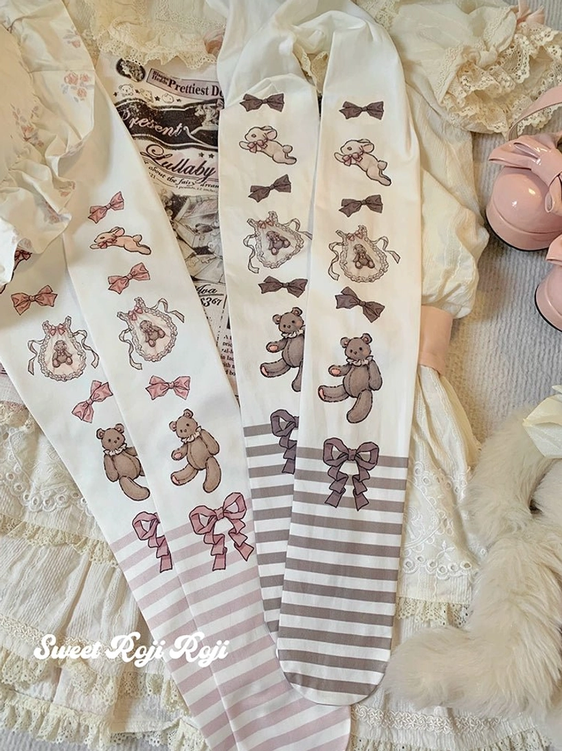 Overhead flat lay display of multiple sweet lolita printed tights pairs in pink and brown variations with bear bow and wreath motifs placed on lace dress fabric pink mary jane shoes