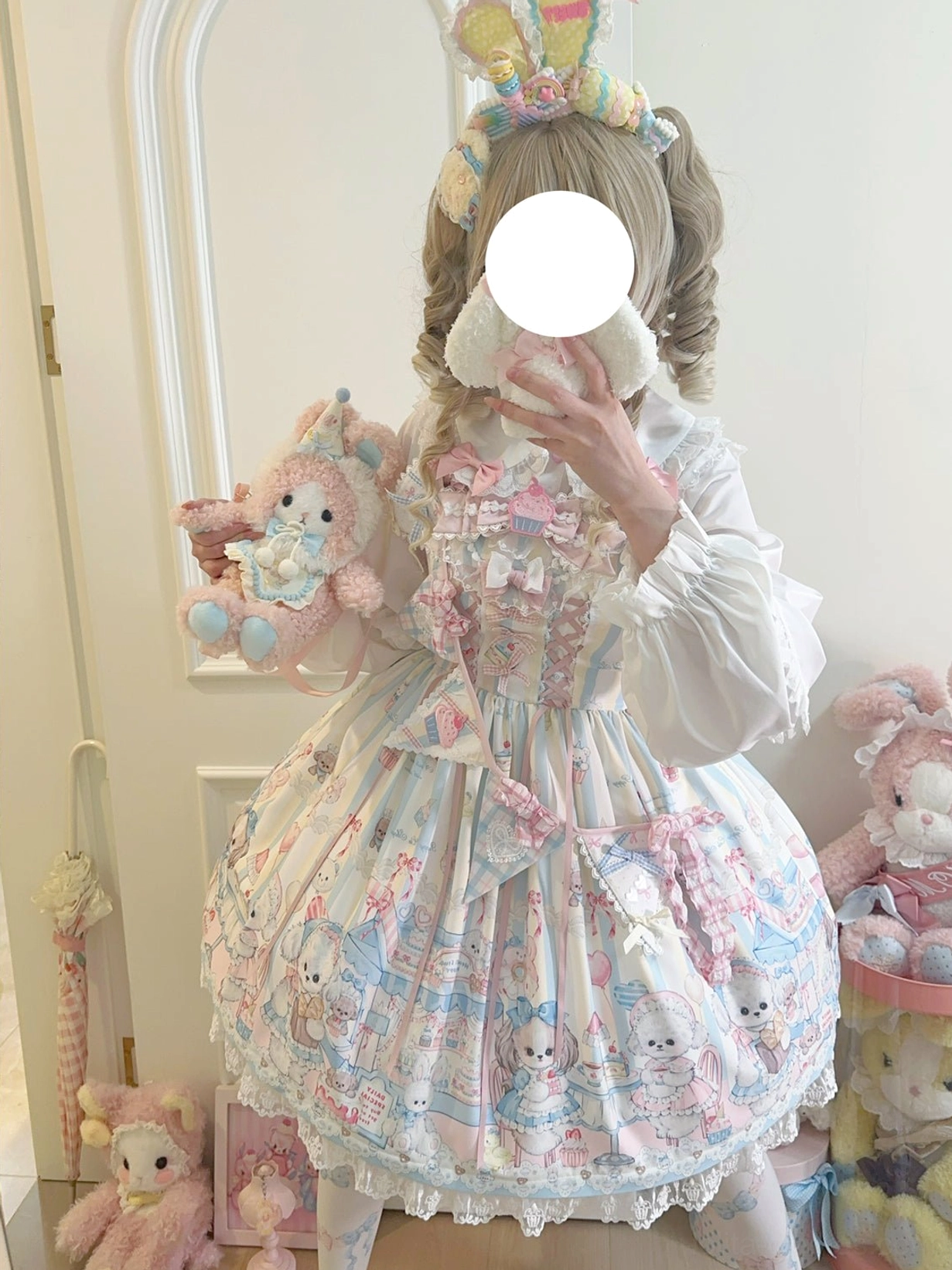 Stylized puppy print sweet Lolita JSK outfit worn by girl with bunny ear hairpiece holding cute plush toy, front mirror view with stacked plush toy barrels background decoration