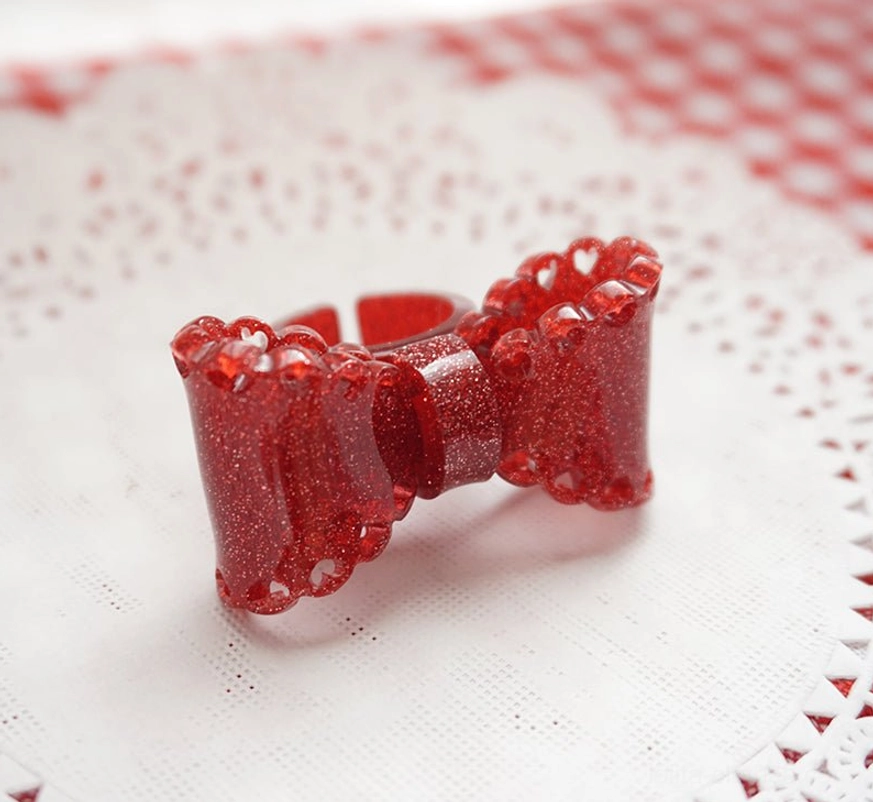 red glitter bow ring front view flat lay deep red resin scalloped edges open ring structure