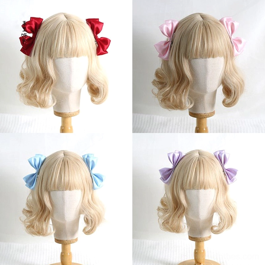 Red Sweet Lolita satin bow hair clips pair worn on blonde curly wig mannequin front close-up view showing detailed bow design and metal alligator clip