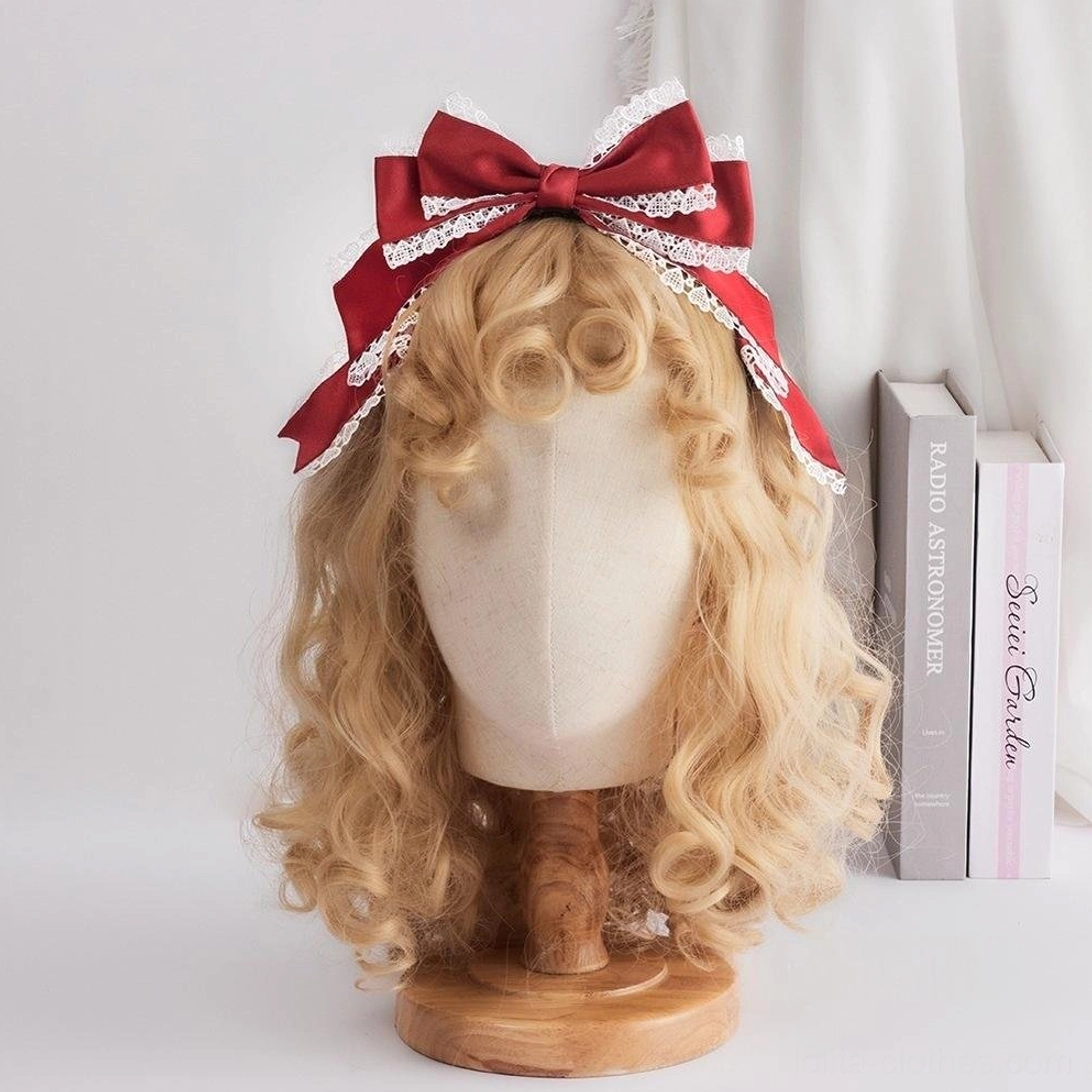 Sweet lolita oversized red satin bow headdress with white scalloped lace trim KC clip attachment front view display on blonde curly wig mannequin