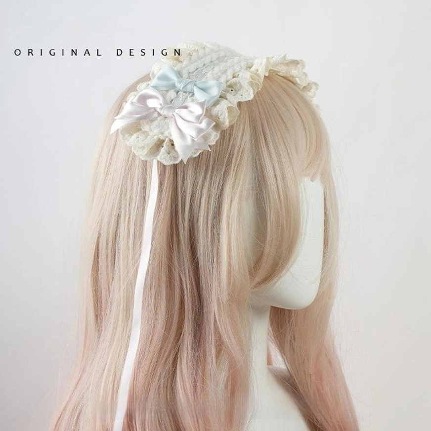 Sweet lolita side bow headband with satin ribbon tail, cream and light blue color scheme, lace bow details, side profile view on blonde wig mannequin