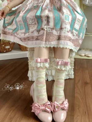 Sweet Lolita mid-calf cotton socks with cream pastel base and gradient print, worn with ruffled detachable pink bow cuff, paired with printed Lolita skirt and pink bow Mary Jane shoes on wooden floor