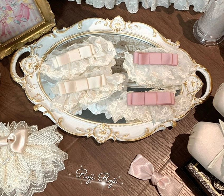 Detachable Sweet Lolita sock cuff accessories on vintage vanity tray showing ivory lace ruffled cuffs with pink and beige bow ornaments and extra matching bow pieces included