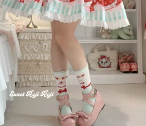Sweet Lolita mid-calf socks side profile showcasing ribbed ankle cuff and red cat festive prints with pink Mary Jane shoes and mint striped lace skirt