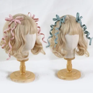 Sweet lolita spiral bow hair clips pair displayed on blonde mannequin heads with wooden stands, featuring pink and mint green ribbon bows with curled tails against white studio backdrop