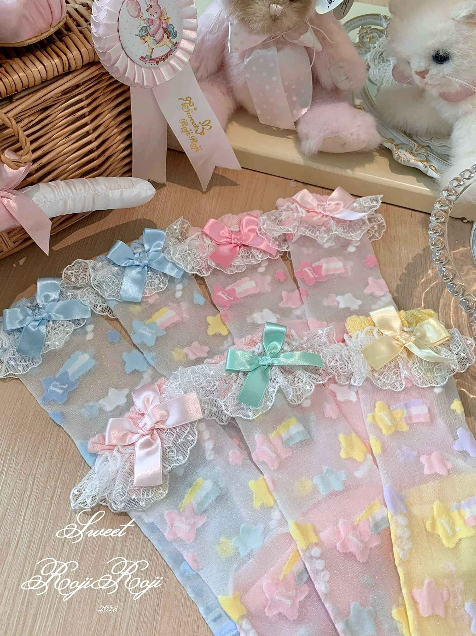 Sweet lolita star embroidered sheer socks flat lay with pastel bow accents and lace cuff ruffles
