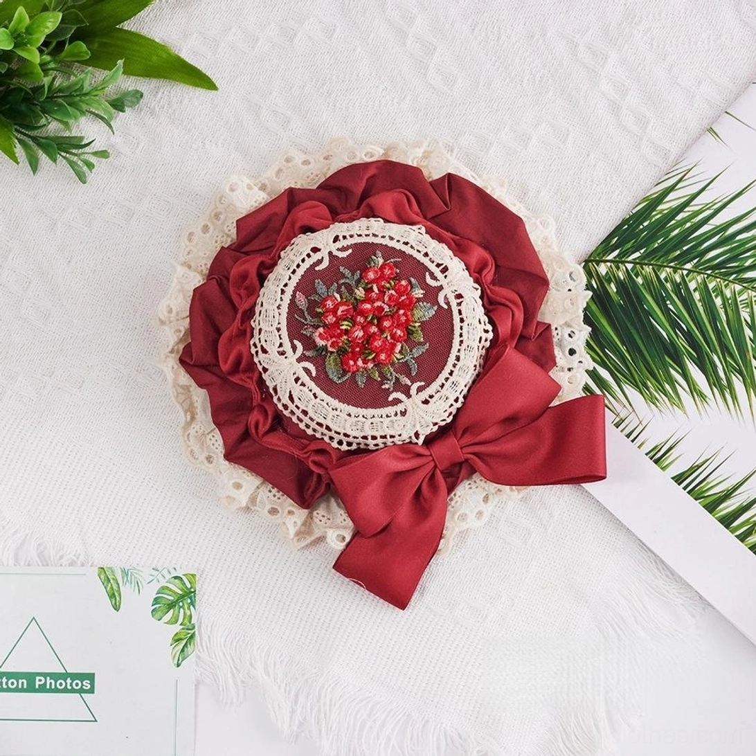 Burgundy Sweet Lolita miniature top hat featuring wine-colored satin ribbon bow, red berry floral embroidery medallion, and delicate white lace border