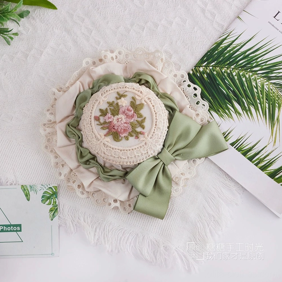 Sweet Lolita top hat display highlighting the contrast between delicate white lace trim and hand-stitched botanical embroidery medallion detail