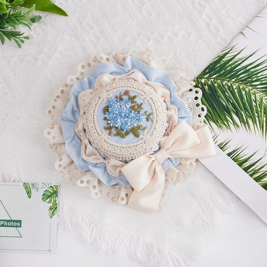 Milky blue Sweet Lolita floral embroidery top hat featuring soft pastel satin bow, intricate hand-stitched flower medallion, and white lace trim