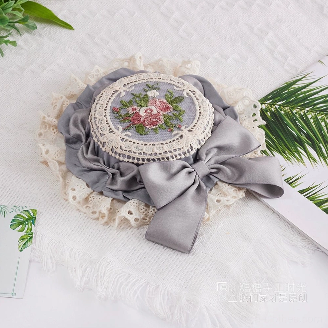 Sweet Lolita floral embroidery top hat showing vintage-inspired design with ornate botanical medallion, ribbon bow, and delicate white lace border