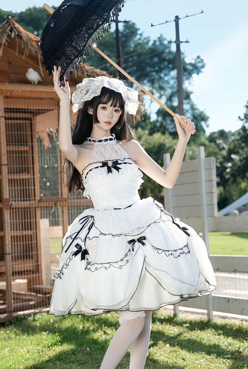 Young model wearing romantic sweet lolita wedding dress with halter neck design, short voluminous ruffled skirt with black accents, matching lace hair bonnet, holding black lace parasol outdoors