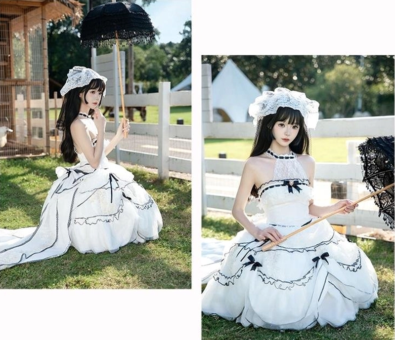 Model sitting outdoors with black lace parasol wearing sweet lolita wedding dress with halter neck top, layered ruffled tulle skirt and long detachable train