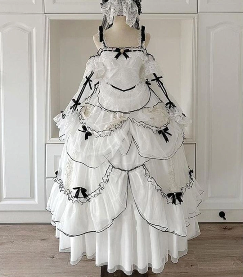 Back full display of sweet lolita wedding dress set on mannequin in wardrobe room showing layered tulle skirt with black trims, back train, lace head veil and halter neck design