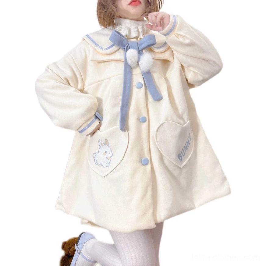 Sweet lolita wool winter overcoat close-up detail shot showing doll collar blue bow white pom-poms fluffy texture front buttons and heart-shaped bunny embroidery pocket design