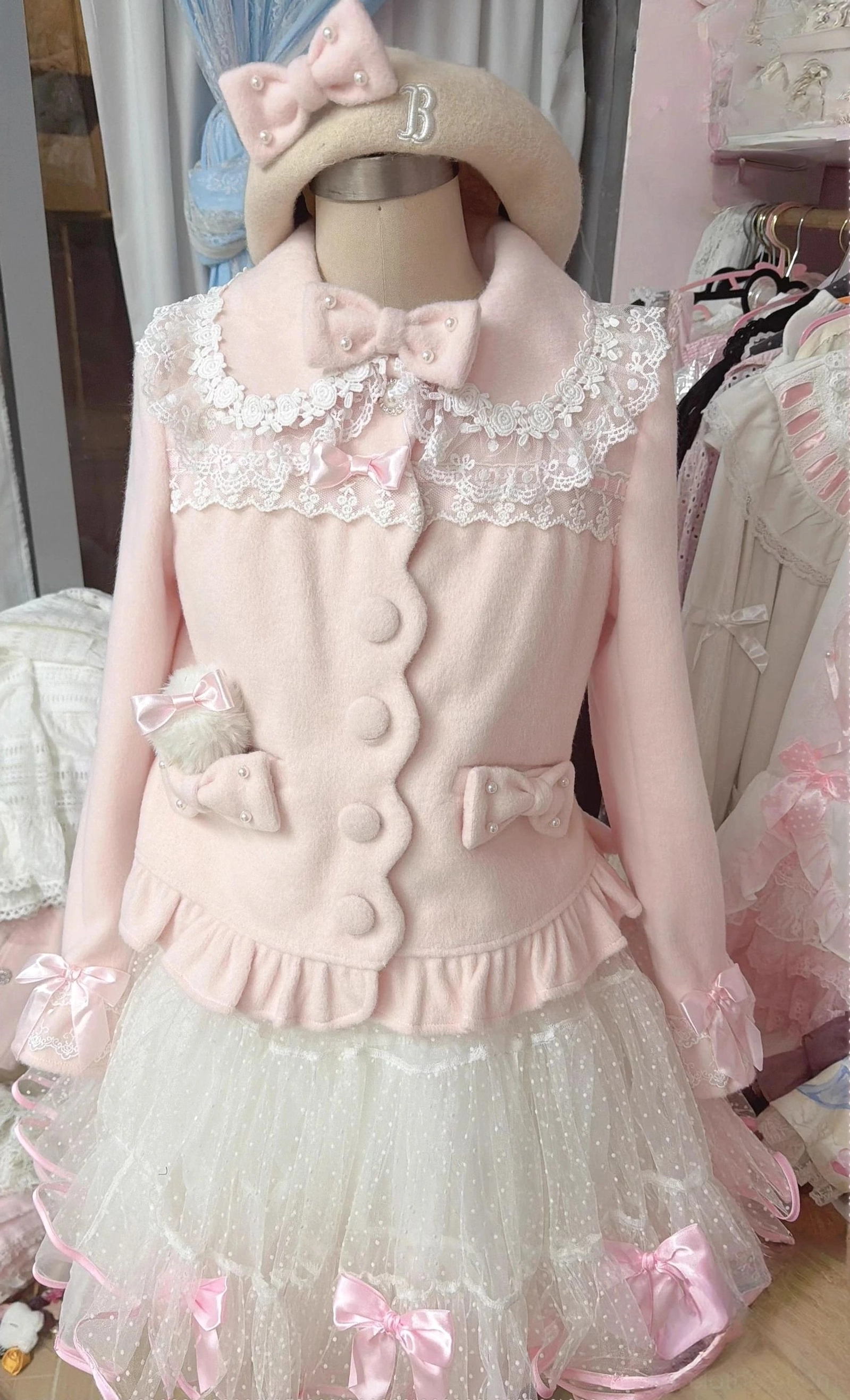 Sweet pink lolita wool coat with tulle skirt set featuring lace peter pan collar and front bow decoration displayed on mannequin