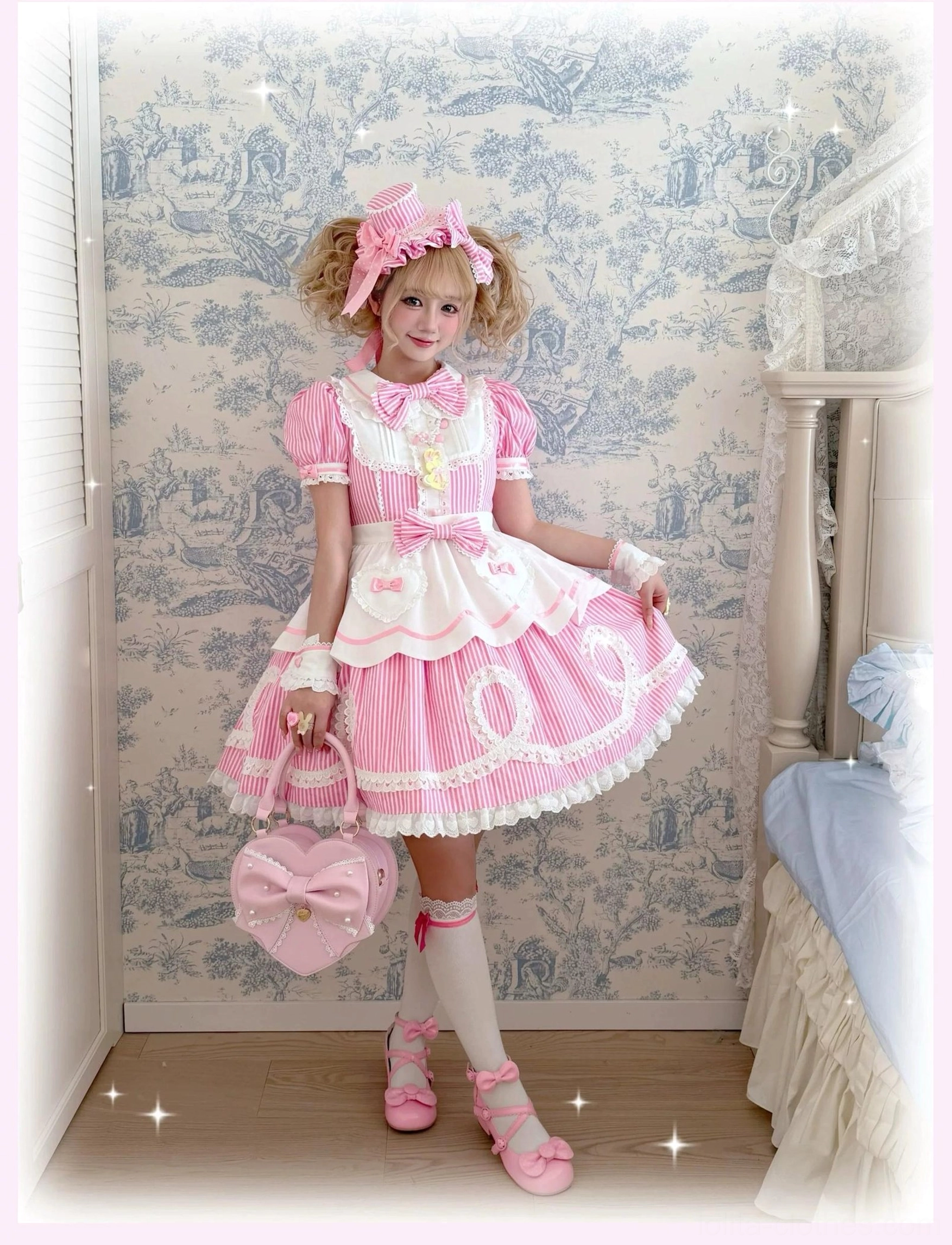 Tea party scene featuring two models in coordinated striped lolita OP dresses wearing bonnets and aprons