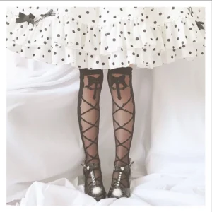 black crisscross lolita thigh high stockings with cross motif scalloped cuff worn with polka dot ruffled skirt and pearl mary jane shoes
