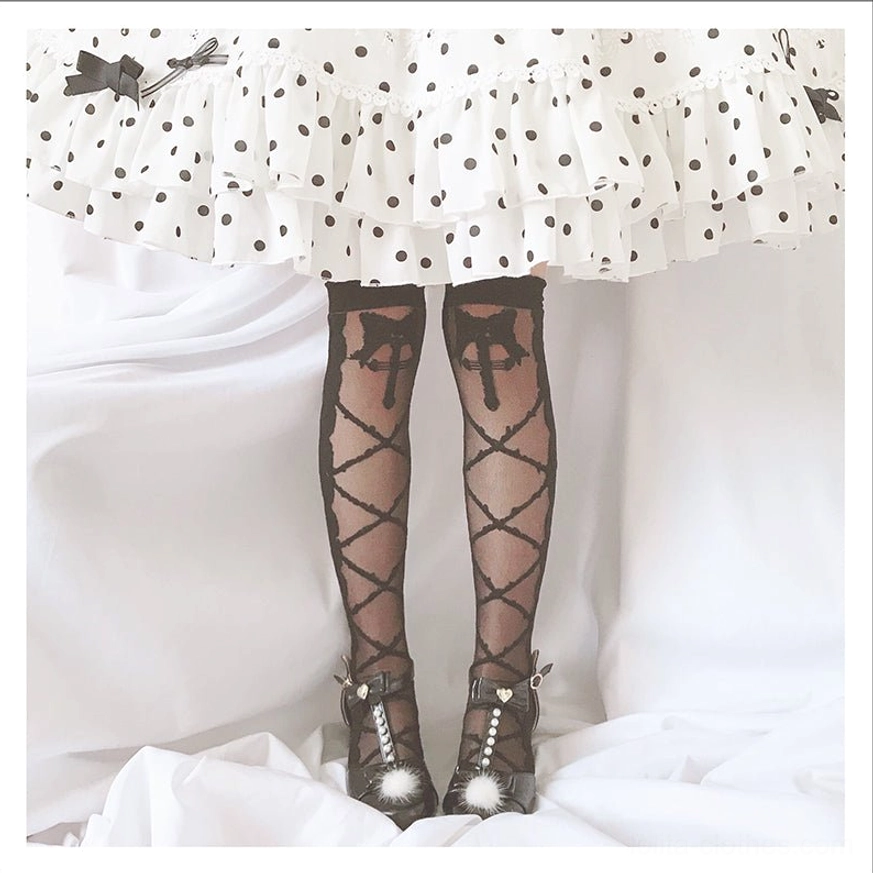black crisscross lolita thigh high stockings with cross motif scalloped cuff worn with polka dot ruffled skirt and pearl mary jane shoes