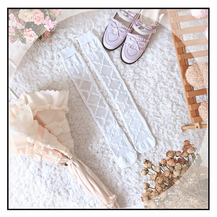 white diamond crisscross lolita thigh high stockings with scalloped top cuff flat lay on fluffy rug with pink mary janes