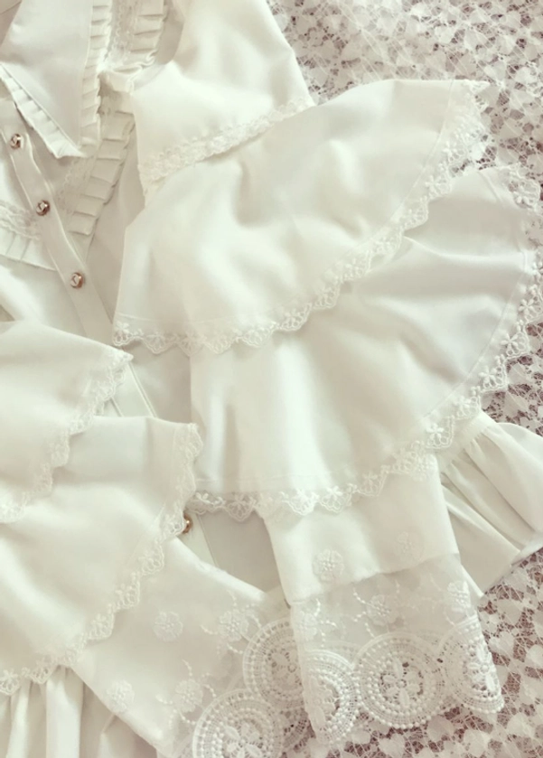 Tiered ruffled lace-trimmed bell sleeve detail flat lay close-up scalloped lace edging matching decorative pleated trims