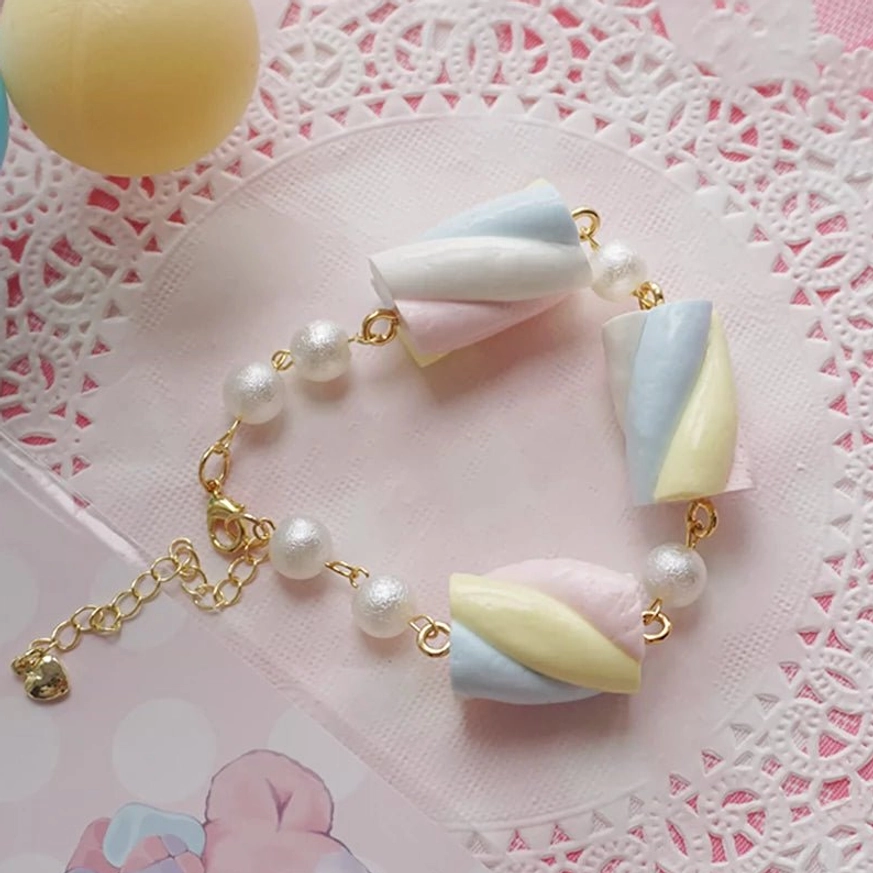 Close-up detail view of yellow blue and pink tri-color cotton candy marshmallow lolita bracelet pendants showing clear metal chain, pearl beads, and complete hardware assembly details