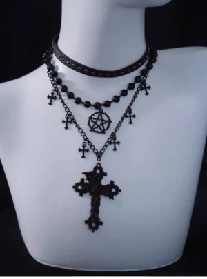 Triple-layer Gothic Lolita choker necklace front view on white mannequin display featuring all-black studded leather choker, beaded chain, tiny cross charms, pentagram pendant and large ornate cross drop pendant