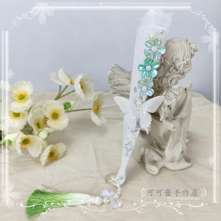 Turquoise cyan blue lolita folding fan side view with white butterfly ornament green gradient tassel and bead pendant detail closed position