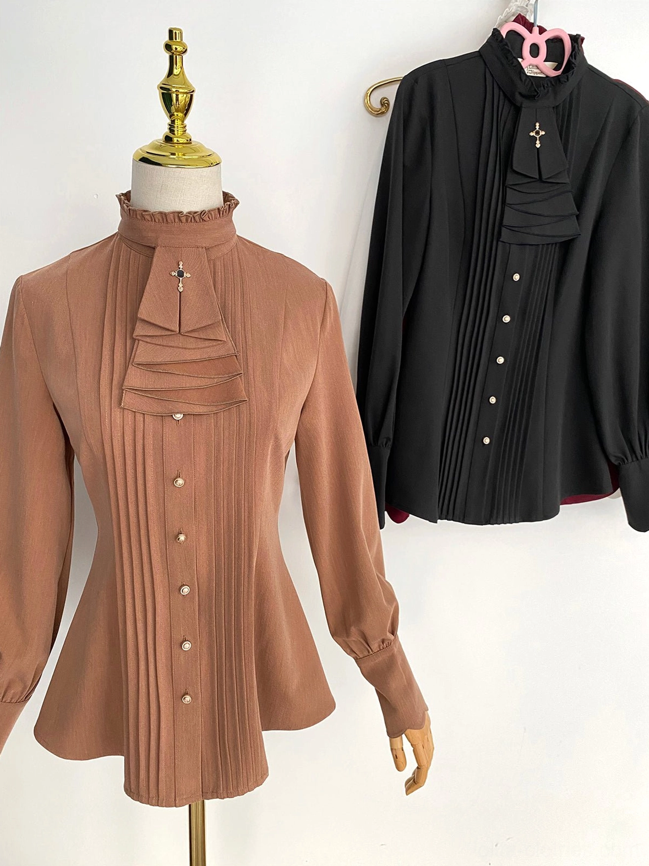Two Lolita stand collar blouses black and tan brown mutton sleeves front view light background pleated front metal buttons puff sleeves