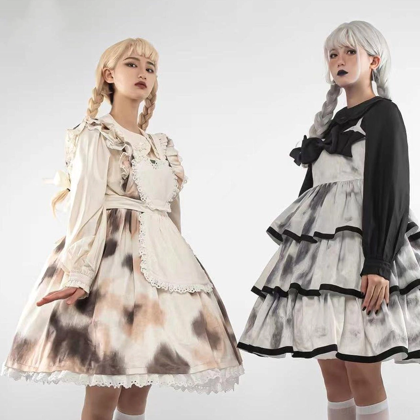 Two maid style lolita dresses side by side models cow print white apron black tiered skirt collar bow