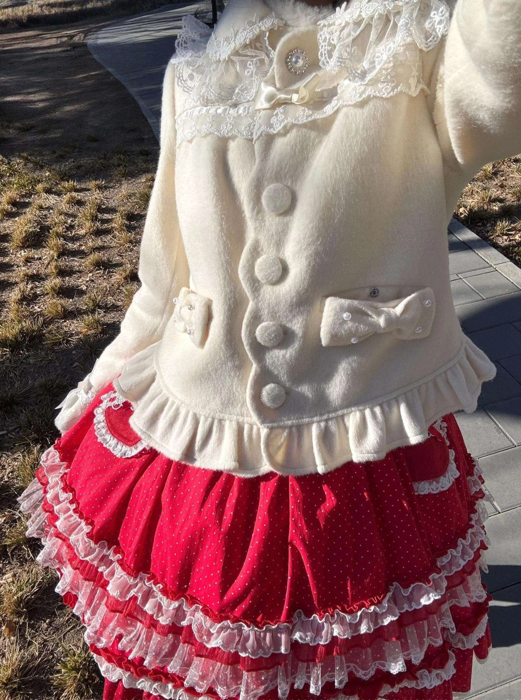 Two-tone lolita coat and skirt coordinate white wool coat with lace collar paired with red polka-dot ruffle layered skirt outdoor display