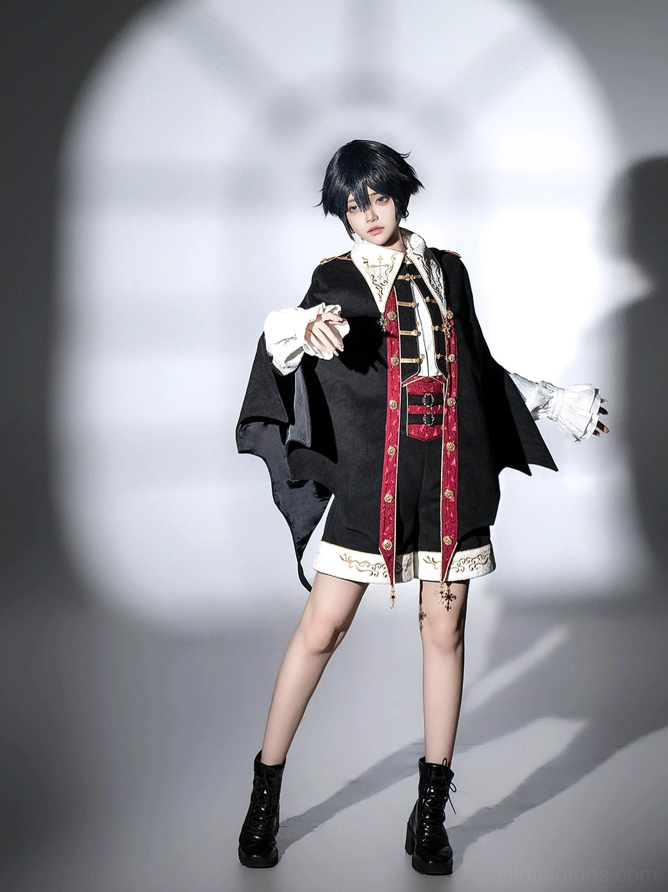 Front three-quarter dynamic open-arm pose in vampire Ouji Lolita bat cape set with visible ruffled shirt cuffs and gold decorative trims