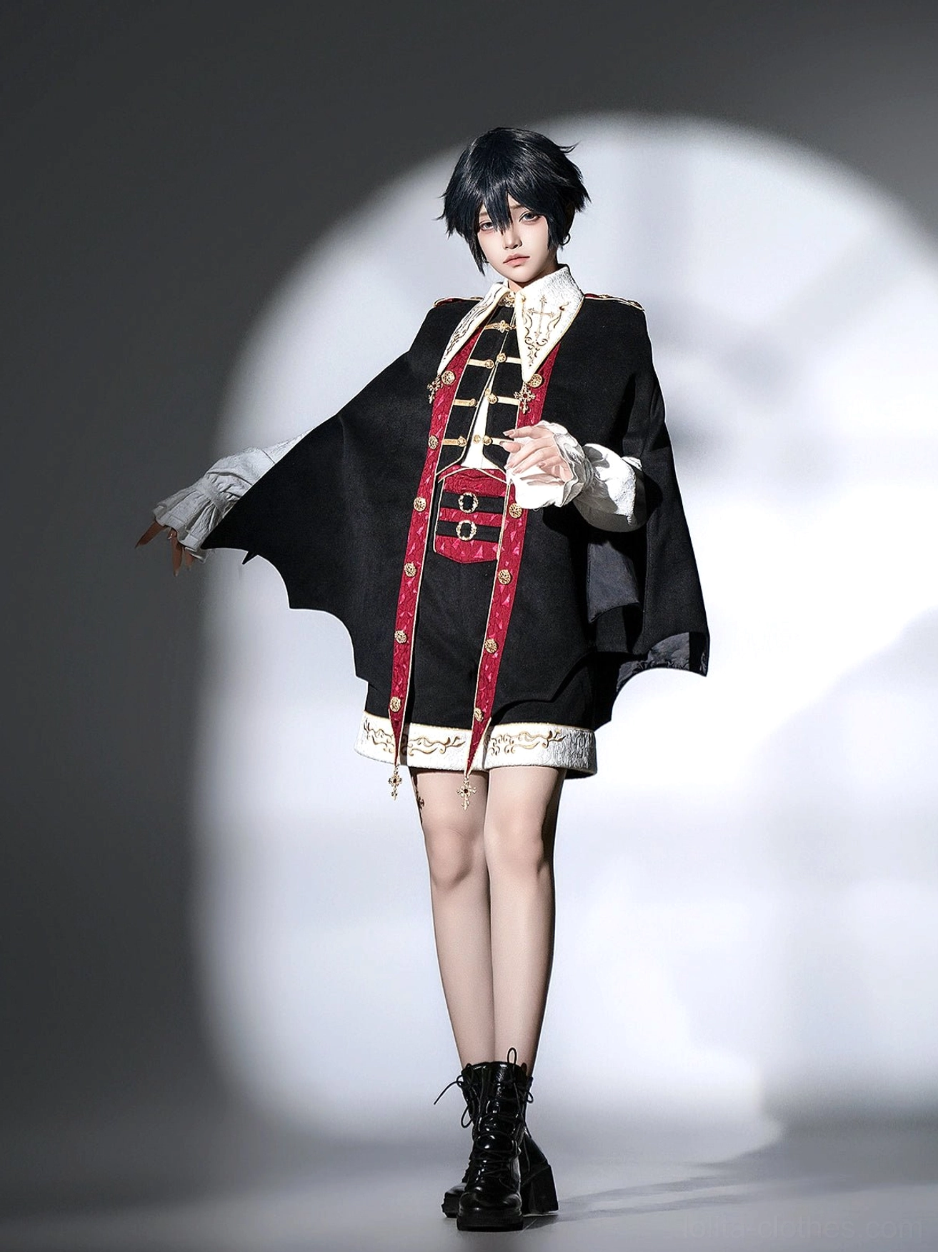 Front full body studio shot of vampire Ouji Lolita bat cape outfit with open-hand pose showing front embroidery tassel details