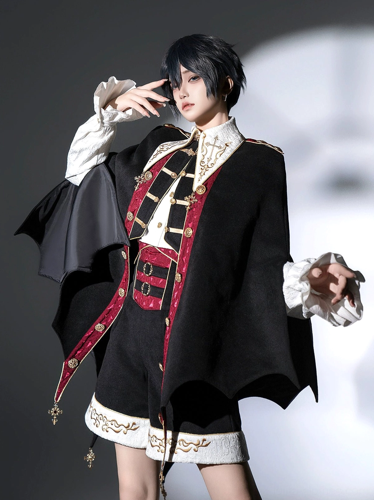 Full front body studio shot of vampire Ouji Lolita three-piece set with wide open-arm pose showing complete front embroidered vest and bat cape