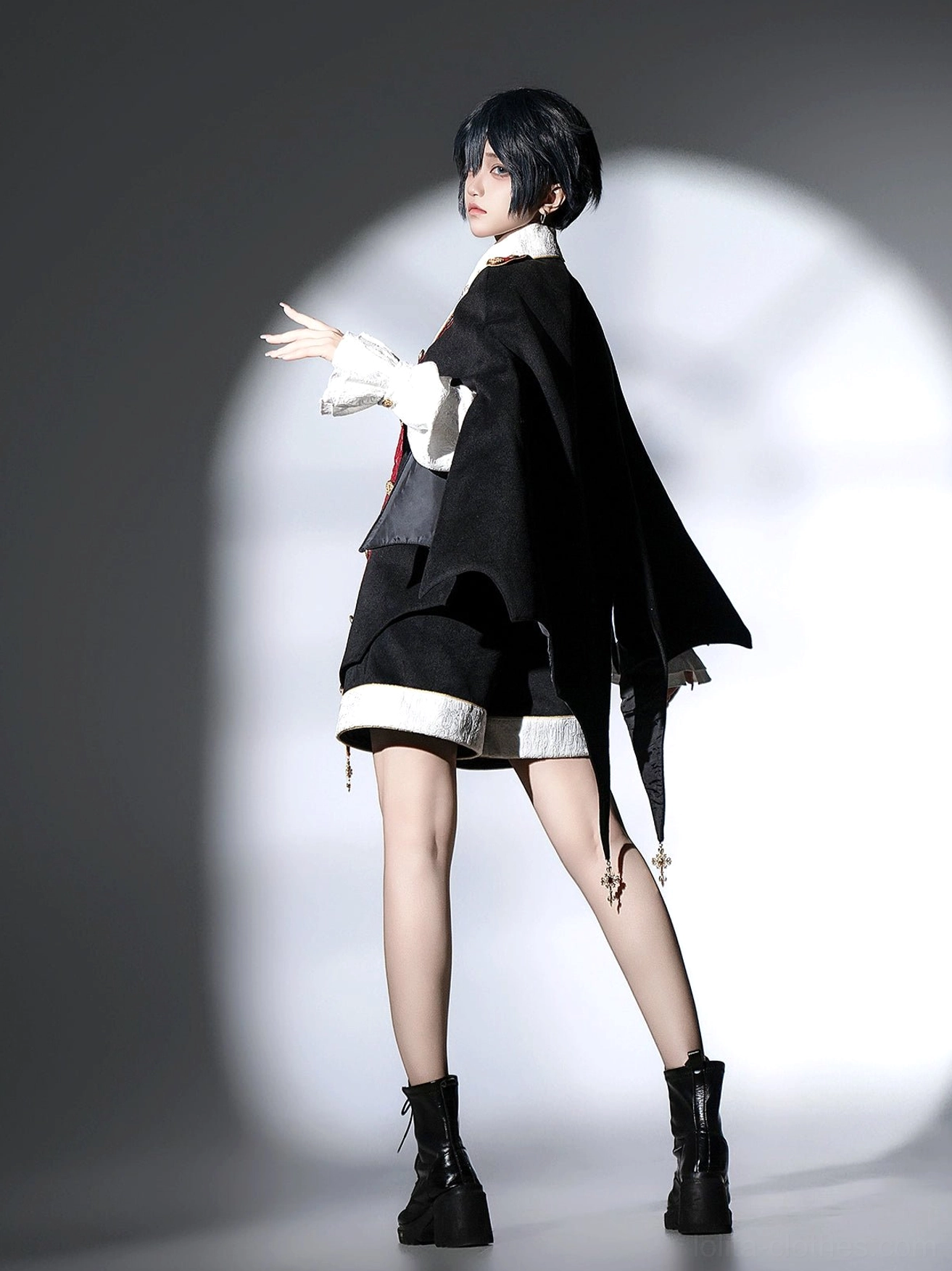 Side three-quarter view of model in vampire Ouji Lolita bat cape set showcasing bat-wing cape silhouette and outfit profile