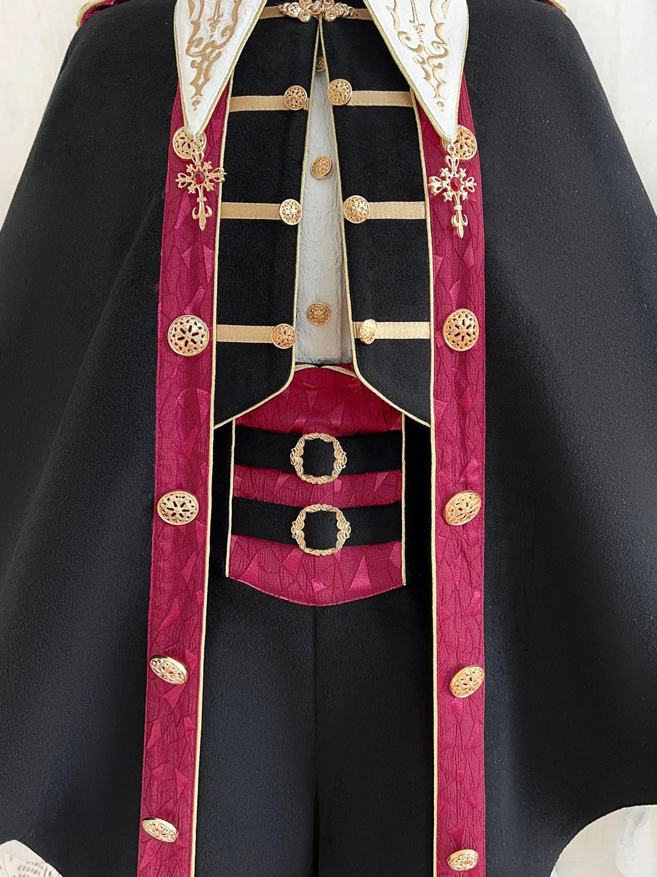 Vampire Ouji Lolita bat cape outfit tassel pendant close-up detail showing gold decorative hem accents and handiwork