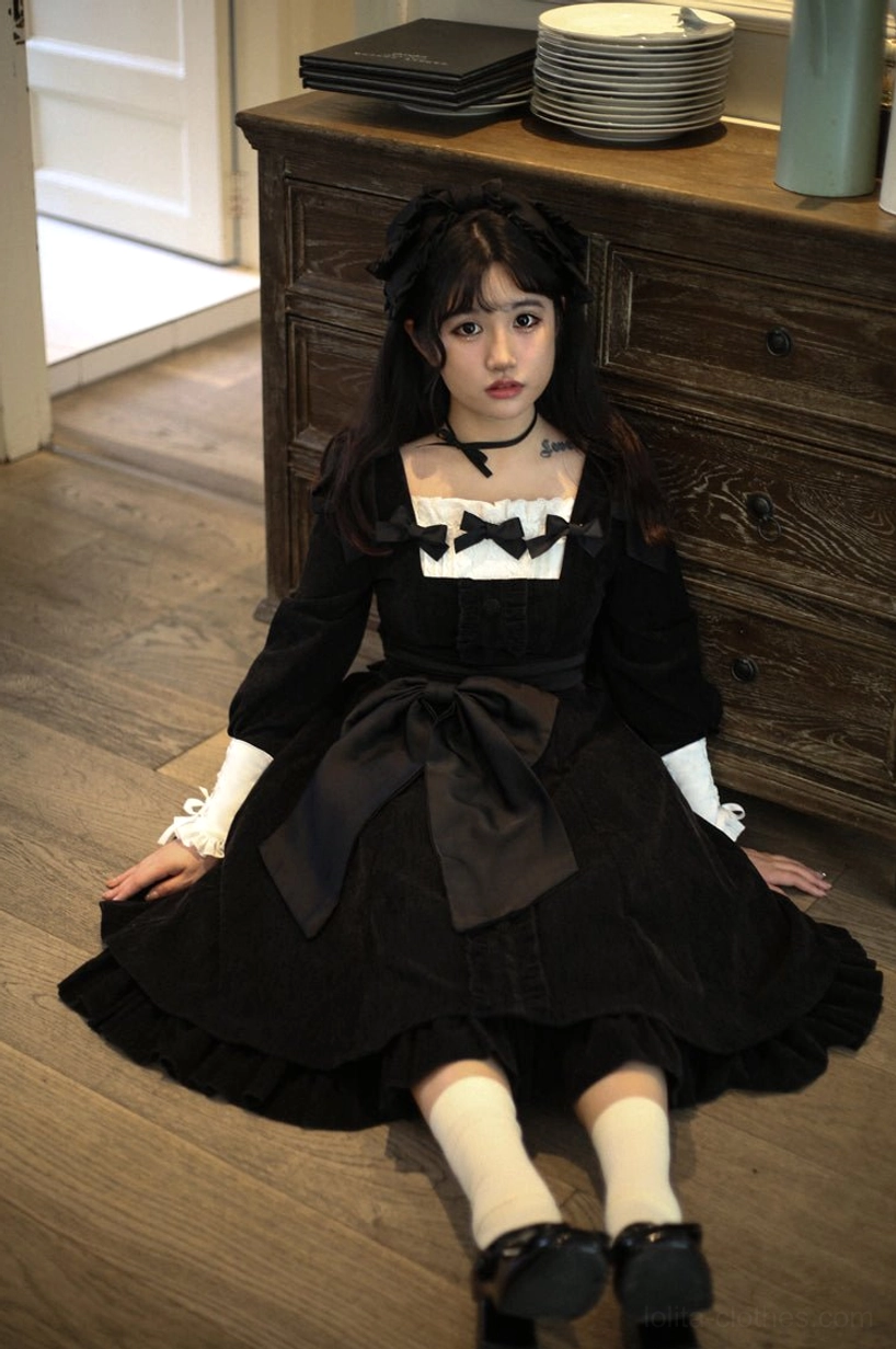 Velvet Lolita OP dress back view photograph displaying lace-up back closure detail, fixed shoulder bow knots, back shirring construction, and ruffled skirt hem from rear perspective