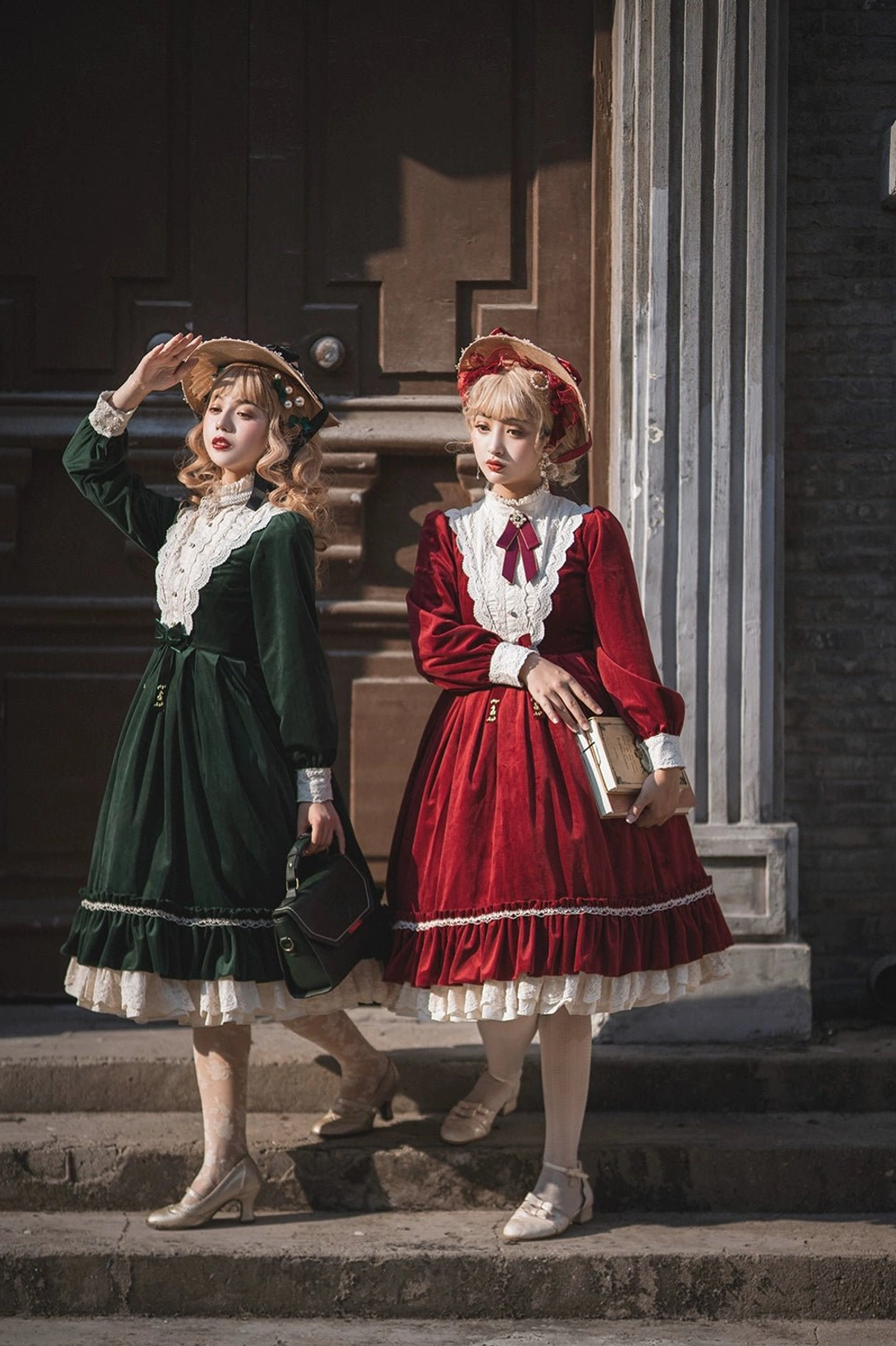 Vintage velvet lolita dress front full-body group shot building doorway steps two models red dress red neck bow green dress purple neck bow coordinated styling