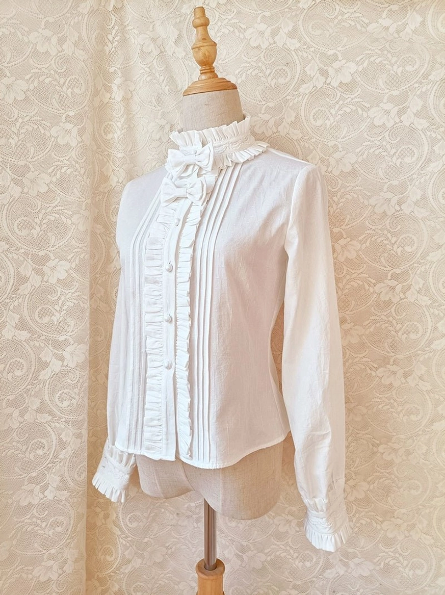 Lolita blouse side three-quarter view showing slim fit long sleeves with ruffled cuffs and stand collar