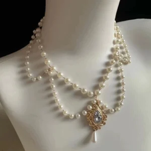 Vintage double-strand imitation pearl Lolita necklace with carved metal pendant featuring prominent gemstone and pearl drop
