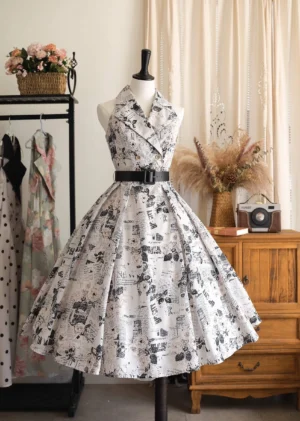 Vintage French-style halter-neck JSK dress with retro newspaper print pattern worn on dress mannequin, featuring notched lapel collar and flared midi-length skirt with black waist belt in retro studio setting