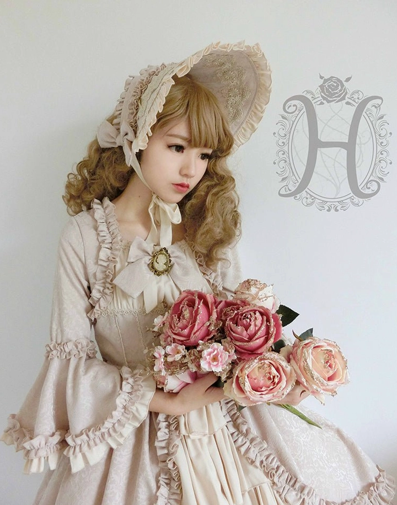 Model wearing vintage Lolita bonnet with matching ivory ruffled gown and rose accessories complete outfit
