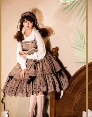 Vintage lolita jumper skirt side half-body view wooden bed background square neck plaid jsk with polka dot details black ribbon bows ruffled white blouse lace hairband