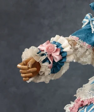 Teal blue lolita ruffled wrist cuff with white layered lace, pink fabric rose, and bow decoration on wooden mannequin hand side angle